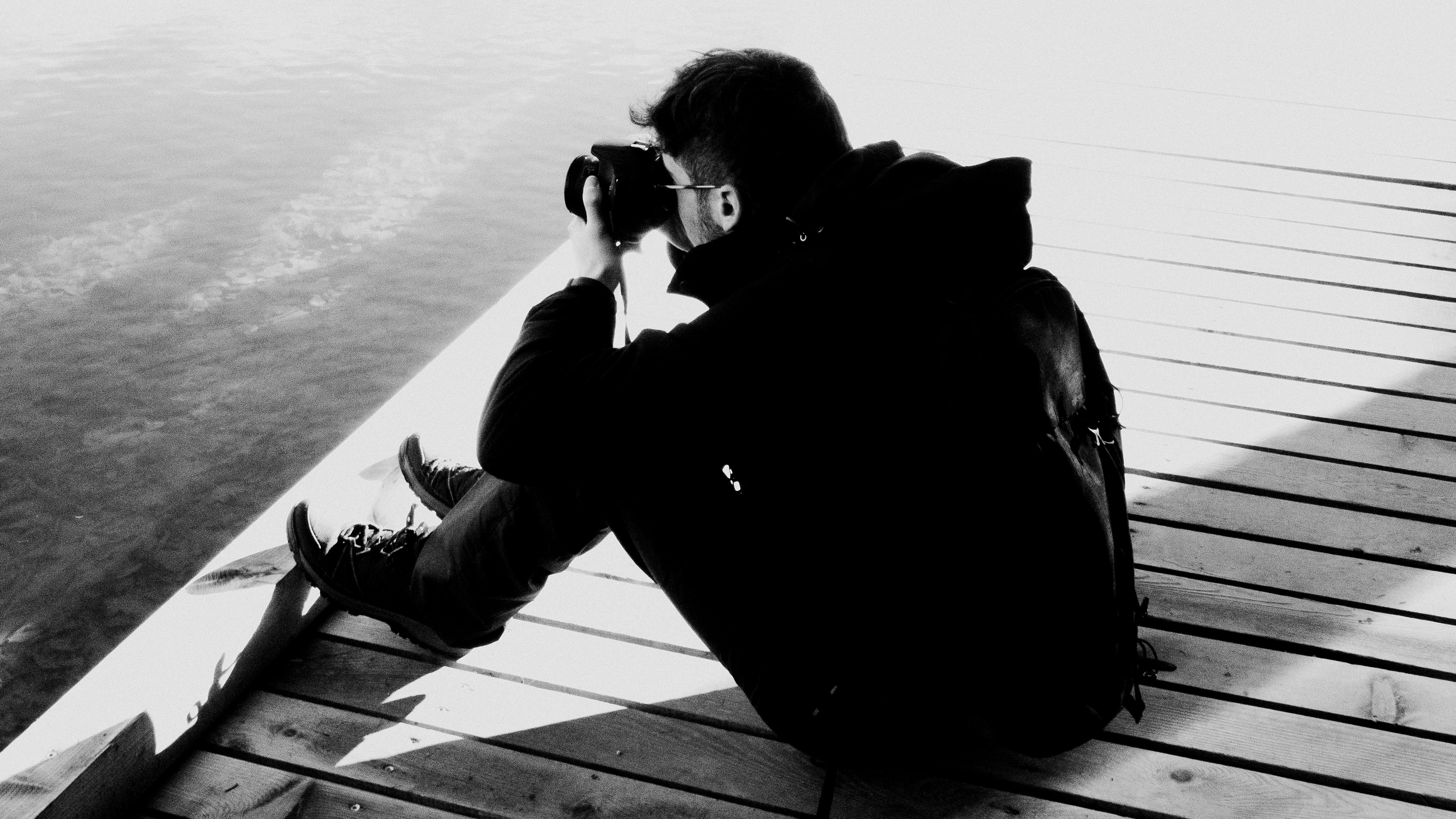 man taking a photo on a wharf